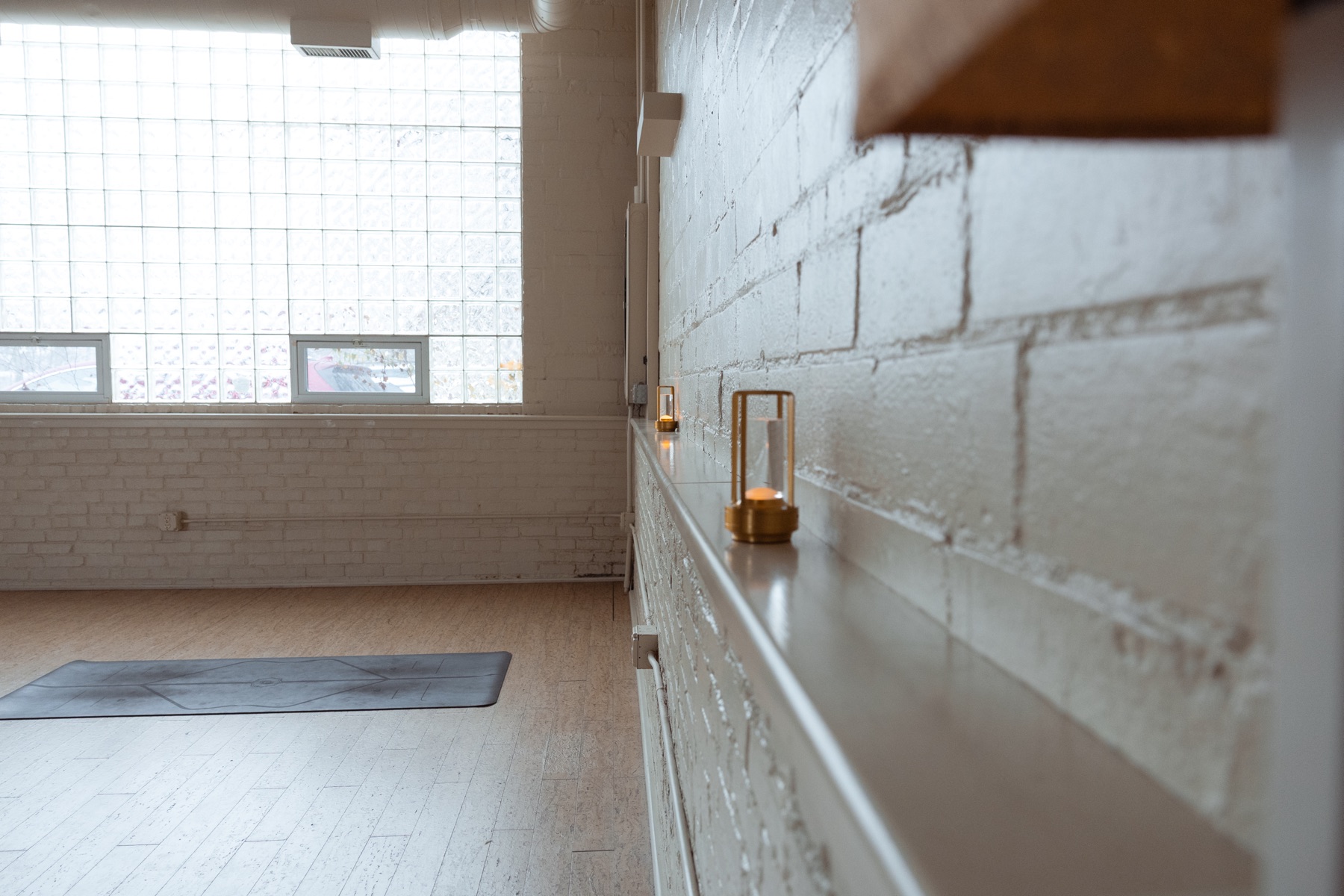 Studio interior with candle, glass block window, and cork floor