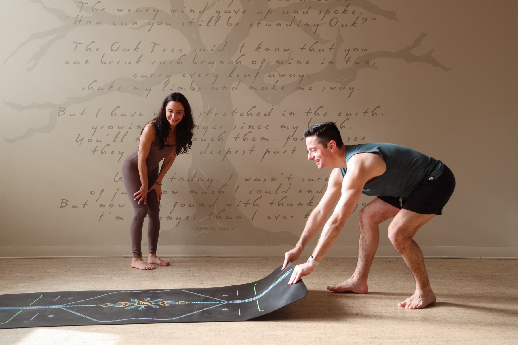 Kim and Scott unrolling mat by poetry wall